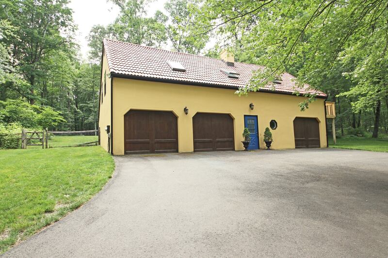 A detached pool house has a heated pool, three garage bays and a second-floor caretaker cottage