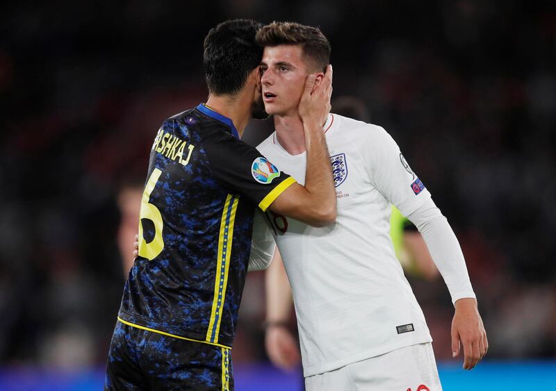 England's Mason Mount is embraced by Kosovo's Anel Raskaj after the match. Reuters
