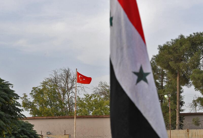 This picture taken from the Syrian Kurdish town of Kobane along the border with Turkey in the north of Aleppo governorate, shows (foreground) a Syrian government national flag and (background) a Turkish national flag flying across both sides of the border between Syria and Turkey. AFP