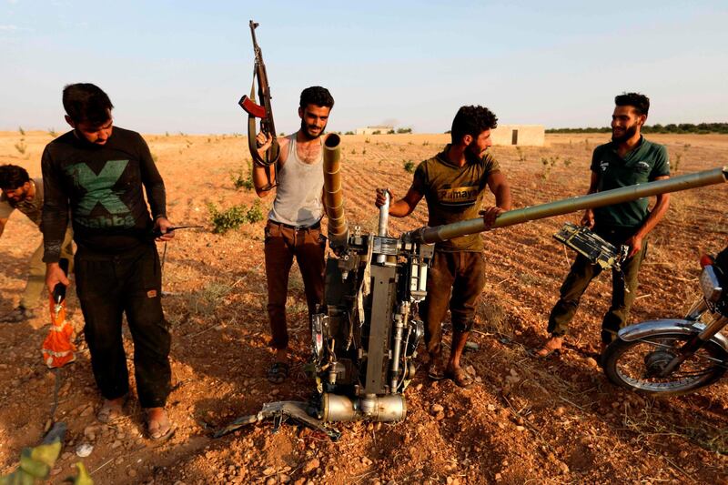 Rebel fighters gather near the remains of a downed regime warplane near the militant-held town of Khan Sheikhun. AFP