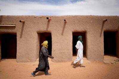 Malian faithfuls walk in the courtyard of the Tomb of Askia in Gao on March 10, 2020. The site, which was protected during the 10 months of jihadist occupation in 2012, represents one of the finest examples of Sudano-Sahelian architecture in the Sahel region. / AFP / MICHELE CATTANI
