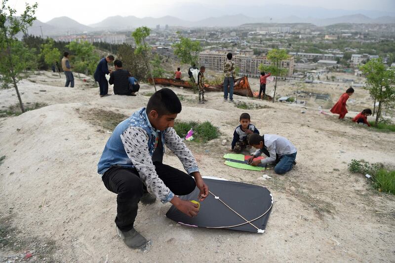 Boys prepare to fly kites during a kite battle.