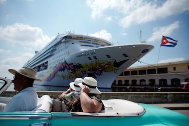 Tourists in a vintage car as they pass by the Norwegian Sky cruise ship, operated by Norwegian Cruise Lines in Havana in May 2019, before the Covid-19 outbreak. Reuters