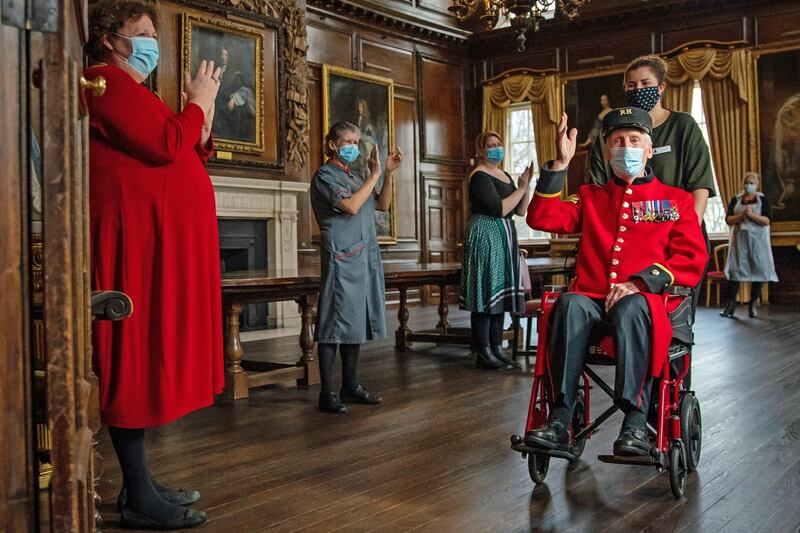 D-Day veteran and Chelsea Pensioner Bob James Sullivan, 98, a resident at the Royal Hospital Chelsea, is applauded by staff after receiving an injection of the Pfizer/BioNTech Covid-19 vaccine from Pippa Nightingale, Chief Nurse at the nearby Chelsea and Westminster Hospital on December 23, 2020. Chelsea Pensioners are all former soldiers of the British Army over the age of 65, who reside at the Royal Hospital Chelsea, founded by King Charles II in 1682, and wear a uniform which includes a scarlet coat. Getty Images