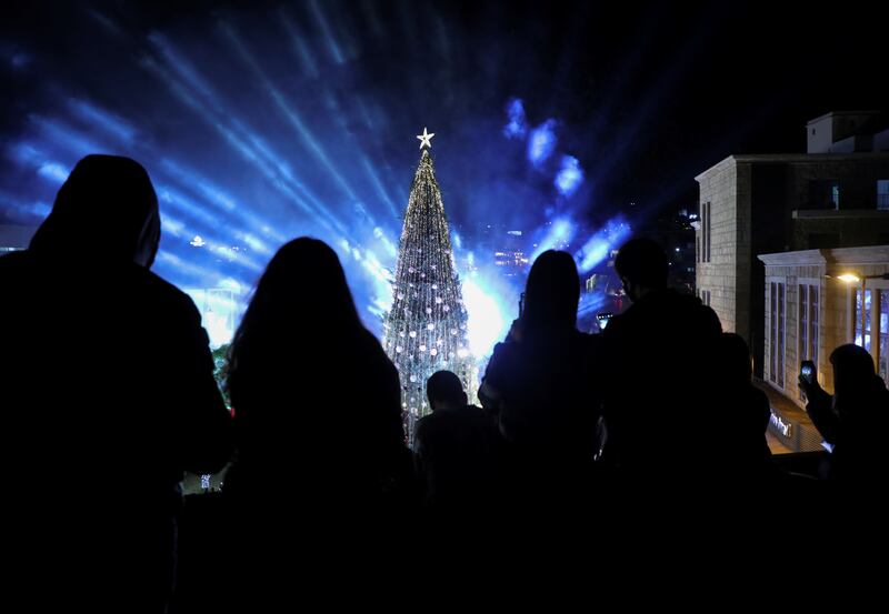 The Christmas tree lights and fireworks illuminate the night sky. Reuters