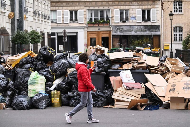 Household waste containers pile up in a street in Paris, after collectors went on strike against the French government's proposed pensions reform. AFP

