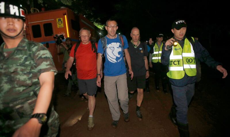 The British Cave Rescue Council members from second left, Robert Charles Harper , John Volanthen and Richard William arrive at cave in the staging area as they continue the search for a young soccer team and their coach believed to be missing in a large cave, Wednesday, June 27, 2018, in Mae Sai, Chiang Rai province, in northern Thailand.  Heavy rainfall stymied efforts to rescue members of a youth soccer team trapped in a cave in northern Thailand by flooding underground passages faster than water can be pumped out, a senior official said Wednesday. (AP Photo/Sakchai Lalit)