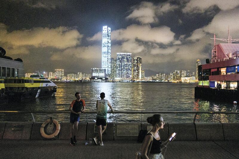 Two friends chat as they stand on a promenade facing Victoria Harbour and the skyline of Kowloon in Hong Kong on May 29, 2020. - The United States and Britain on May 29 defied China's anger by raising Hong Kong's autonomy at the UN Security Council as President Donald Trump prepared new measures against Beijing. (Photo by Anthony WALLACE / AFP)