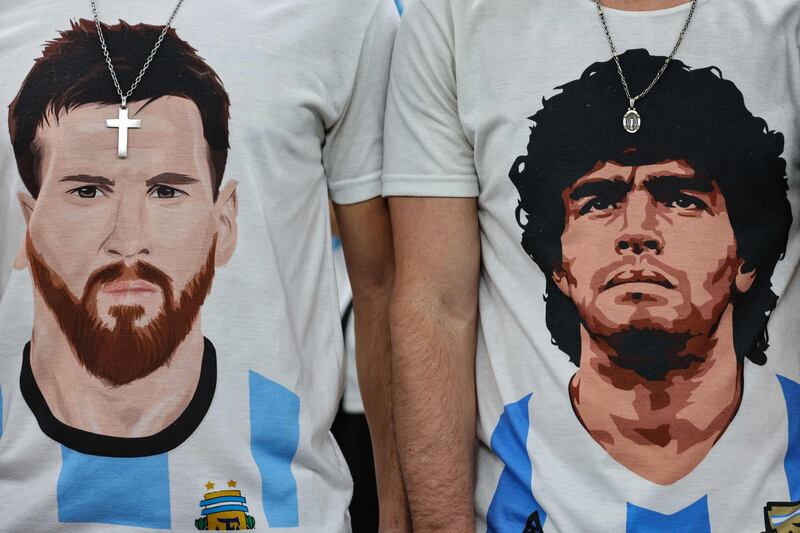 Argentina supporters wear t-shirts displaying portraits of Argentina's forward #10 Lionel Messi (L) and late football legend Diego Maradona. AFP