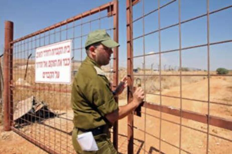 An Israeli army officer closes the entrance gate to a cemetery for enemy combatants marked with numbered plaques near the northern Israeli town of Tsfat. A prisoner swap is due to take place between Israel and Hizbollah militia in about 10 days.