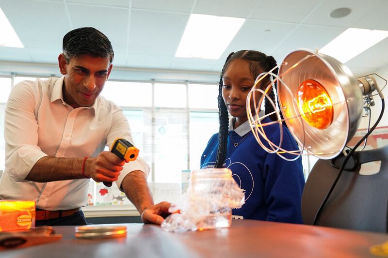 Rishi Sunak takes part in a science experiment as he visits the Friendship Technology Preparatory High School. Reuters