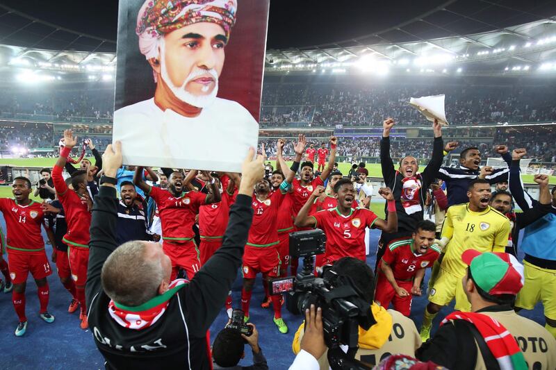 Oman's players celebrate in front of a portrait of Oman's Sultan Qaboos after winning the Gulf Cup of Nations 2017 final football match between Oman and the UAE at the Sheikh Jaber al-Ahmad Stadium in Kuwait City on January 5, 2018. / AFP PHOTO / Yasser Al-Zayyat
