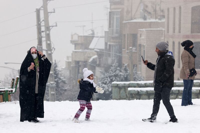 Iranians enjoy time in the park during snowfall in the capital Tehran. AFP