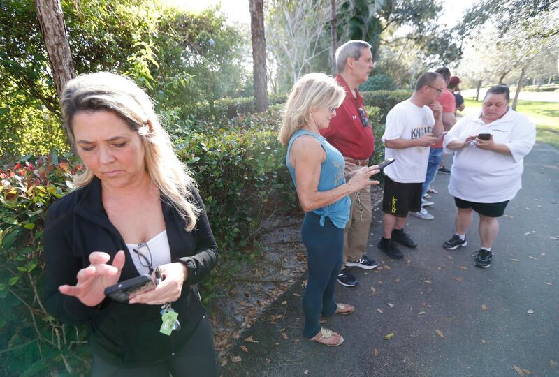 Anxious family members wait for information on students, Wednesday, Feb. 14, 2018, in Parkland, Fla. A shooting at Marjory Stoneman Douglas High School sent students rushing into the streets as SWAT team members swarmed in and locked down the building. Police were warning that the shooter was still at large even as ambulances converged on the scene and emergency workers appeared to be treating those possibly wounded. (AP Photo/Wilfredo Lee)