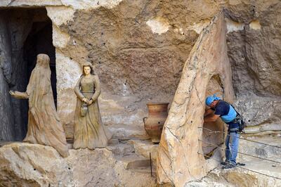 Polish artist Mario, sculptor of St. Simon the Tanner Monastery complex, works on a scene at the church in the Egyptian capital Cairo's eastern hillside Mokkatam district, on May 30, 2019. Mario spent more than two decades carving the rugged insides of the seven cave churches and chapels of the rock-hewn St. Simon Monastery and church complex atop Cairo's Mokkatam hills, with designs inspired by biblical stories. It was all done to fulfil the wishes of the church's parish priest who met Mario in the early 1990s in Cairo. The Polish artist, who had arrived in Egypt earlier on an educational mission, was then looking for an opportunity to serve God at the monastery. / AFP / Mohamed el-Shahed
