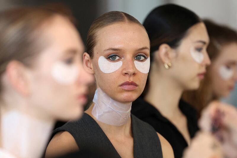 Models prepare backstage for the Badgley Mischka Fall/Winter 2024 collection show at New York Fashion Week. Reuters