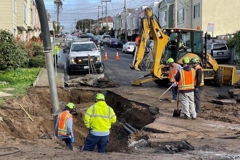 Crews at a sinkhole from recent storms in Daly City, California, as residents brace for more extreme weather. AP