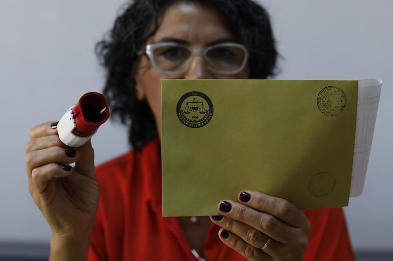 An electoral official holds an envelop at a polling station in Istanbul, on Sunday, June 23, 2019. AP Photo