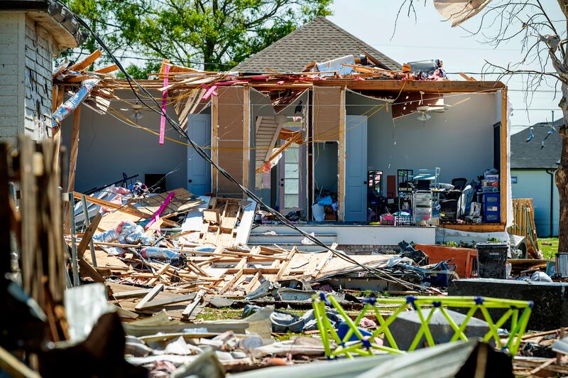 Debris litters the ground next to a severely damaged home following Tuesday night's tornado, in Arabi, Louisiana. The Daily Advertiser / AP