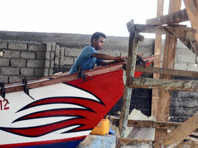A young man from Al-Khoukhah manufacturing boats in the factory of Homadi. Ali Mahmood-Al-Khoukhah for The National