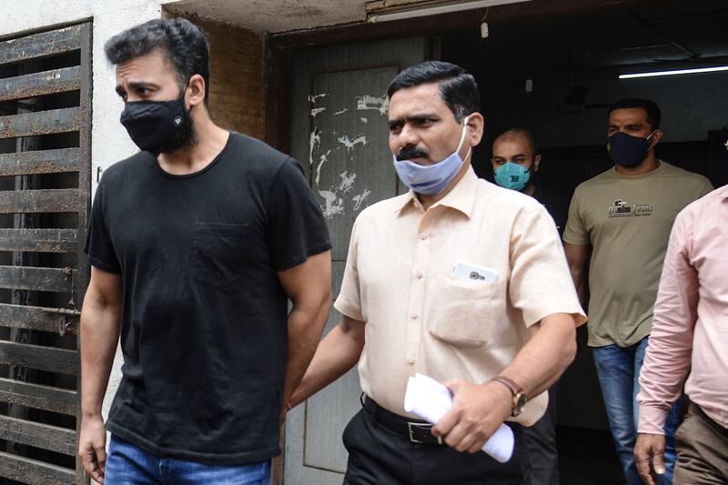 Mumbai Police's Crime Branch team escort Bollywood actress Shilpa Shetty's husband Raj Kundra (L) for allegedly producing and broadcasting pornographic films online, in Mumbai on July 27, 2021.  AFP