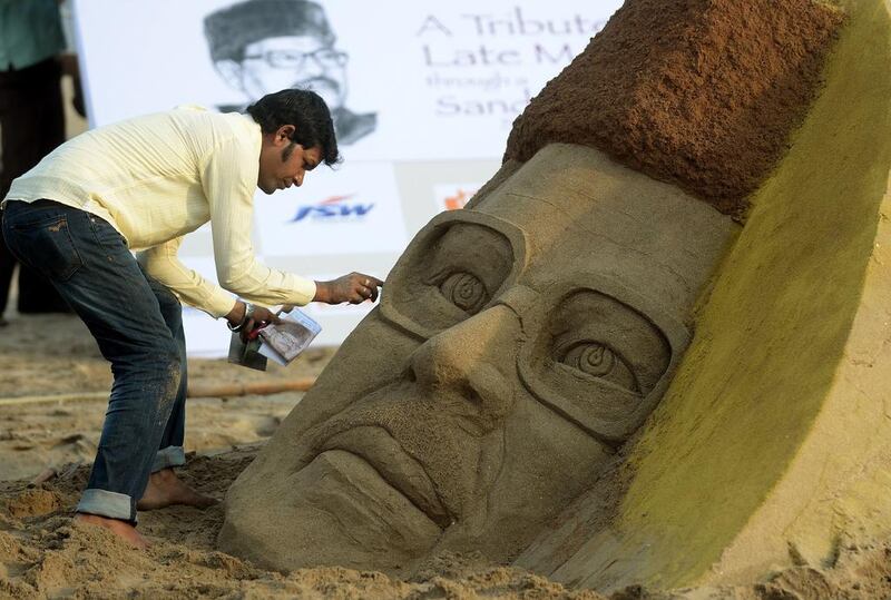 An Indian artist creates a sand sculpture of the late Bollywood playback singer Manna Dey. Punit Paranioe / AFP