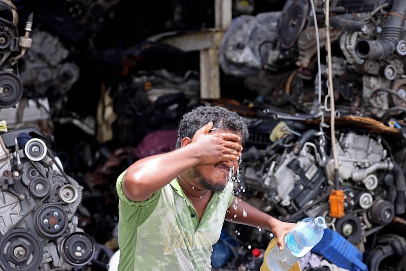 A worker washes his face to cope with the hot weather in Dubai. AFP