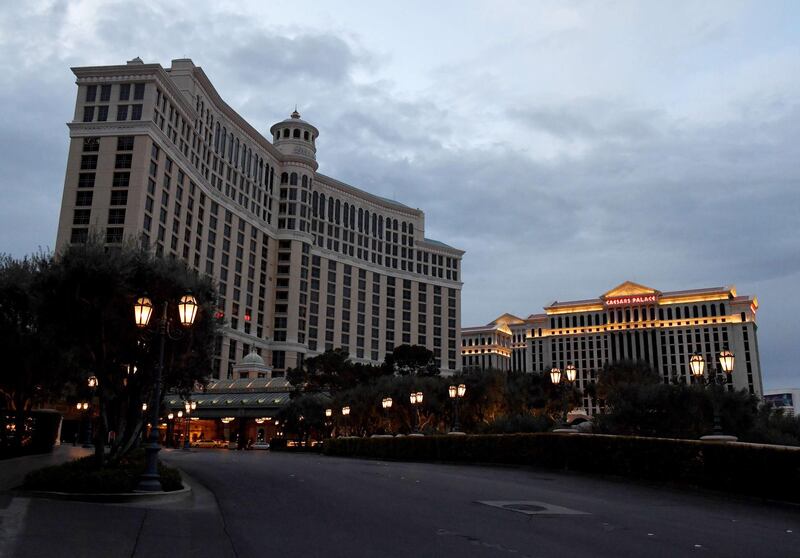 Most of the exterior building lights at Bellagio Resort & Casino, shown to the left of Caesars Palace, are turned off as parts of the Las Vegas Strip go dark as a result of the statewide shutdown due to the coronavirus.   Getty Images