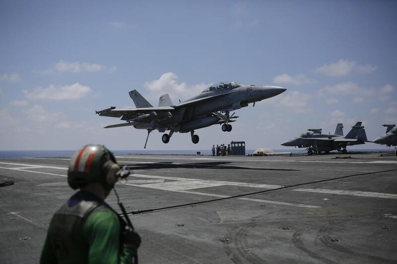 A US fighter jet lands on the USS George H W Bush aircraft carrier in the Mediterranean Sea after a bombing mission against ISIL in Iraq and Syria. Bram Janssen / AP Photo / June 22, 2017