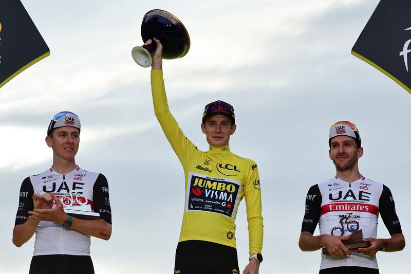 Tour de France winner Jonas Vingegaar, centre, alongside Tadej Pogacar, left, who came second and third-placed Adam Yates on the podium after the final stage in Paris on July 23, 2032. EPA