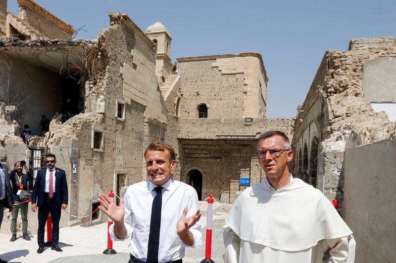 French President Emmanuel Macron gestures as he visits Al-Sa'ah church in the Old City of Mosul. Reuters