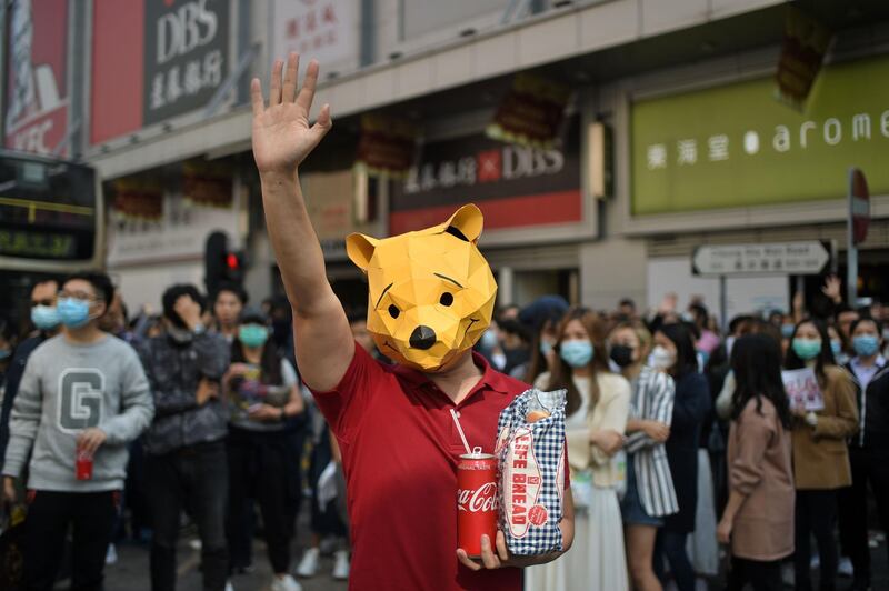 A man wears a “Winnie the Pooh“ mask as he joins others in a lunchtime flash mob rally in the Cheung Sha Wan district in Hong Kong on November 29, 2019. Hong Kong has been battered by months of mass rallies and violent clashes pitting police against protesters who are agitating for direct popular elections of the semi-autonomous Chinese territory's government, as well as a probe into alleged police brutality. / AFP / Philip FONG
