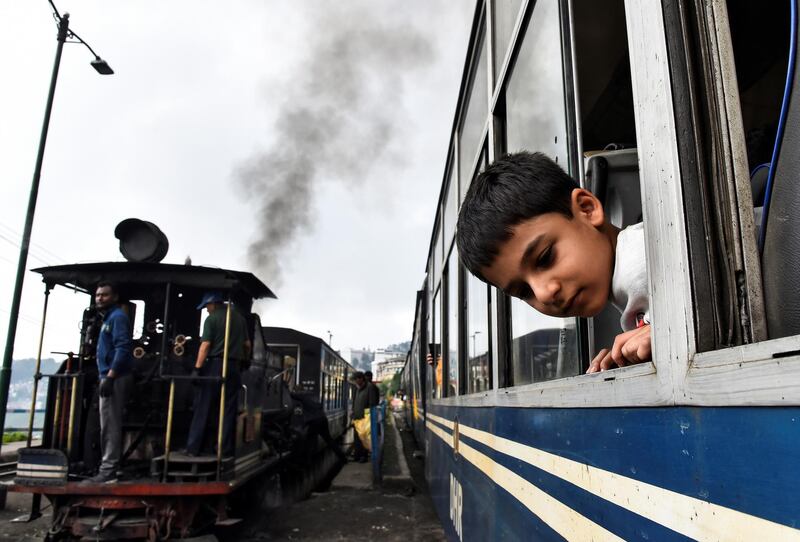 A boy looks out of a Darjeeling Himalayan Railway train in Darjeeling.