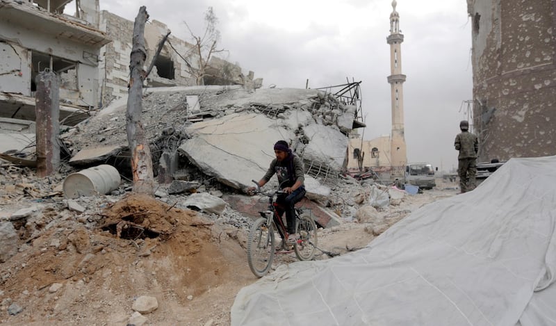 epa06755988 A man rides a bicycle amid damaged building at the Yarmouk Camp district in south Damascus, Syria, 22 May 2018. Media reports state the Syrian government of Bashar al-Assad on 21 May recaptured the last area of Damascus under opposition control and took full control of the capital for the first time since the outbreak of the civil war in 2011, after groups of Islamic State (IS) fighters holed up in an area of south Damascus, including the Palestinian refugee camp Yarmouk, were bussed out.  EPA/YOUSSEF BADAWI