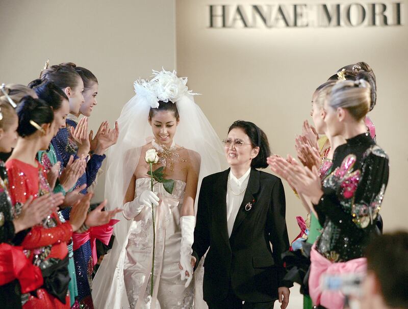 (FILES) This file photo taken on July 7, 2004 shows Japanese designer Hanae Mori (centre R) walking on the catwalk after the presentation of her autumn-winter 2004-05 haute couture collection in Paris.  - Japanese fashion designer Hanae Mori, who cracked the elite world of Parisian haute couture, has died at her home in Tokyo aged 96, Japanese media reported on August 18, 2022.  (Photo by JEAN-PIERRE MULLER  /  AFP)