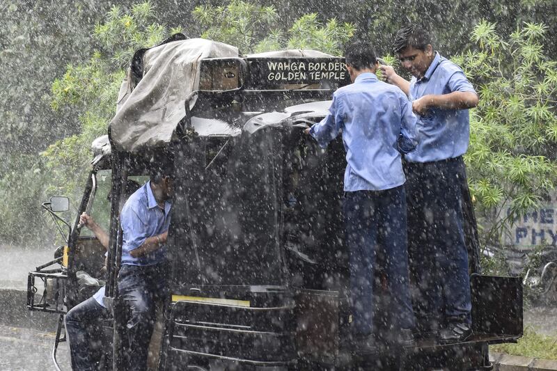 Pupils travel on an auto-rickshaw during heavy rain in Amritsar last week.  AFP