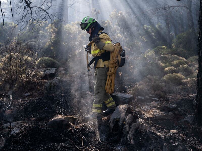A firefighter extinguishing hotspots after the wildfire displaced about 3,000 people from their homes. AP Photo