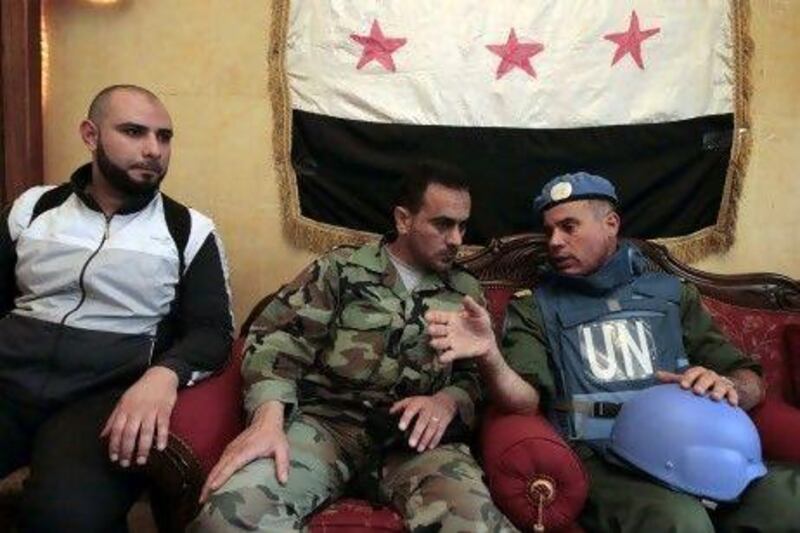 The head of the United Nations observation team, Col Ahmed Himmiche, right, speaks with the Free Syrian Army commander Abu Kutaiba in the old city of Homs yesterday. Regime forces reportedly killed students at university in Aleppo yesterday, casting new doubt on the UN peace plan.