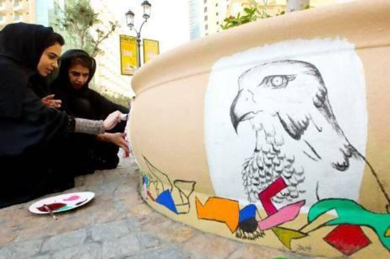 The artists Ayesha Al Saeed, 24, left, and her friend Alia Abdulla, 26, work on an installation on the JBR Walk in Dubai. Christopher Pike / The National