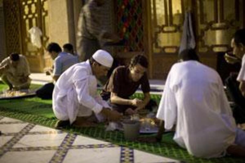 Abdul Hameed al Warhi, 23, centre, a Sufi follower, breaks fast at Tijani zawiya.