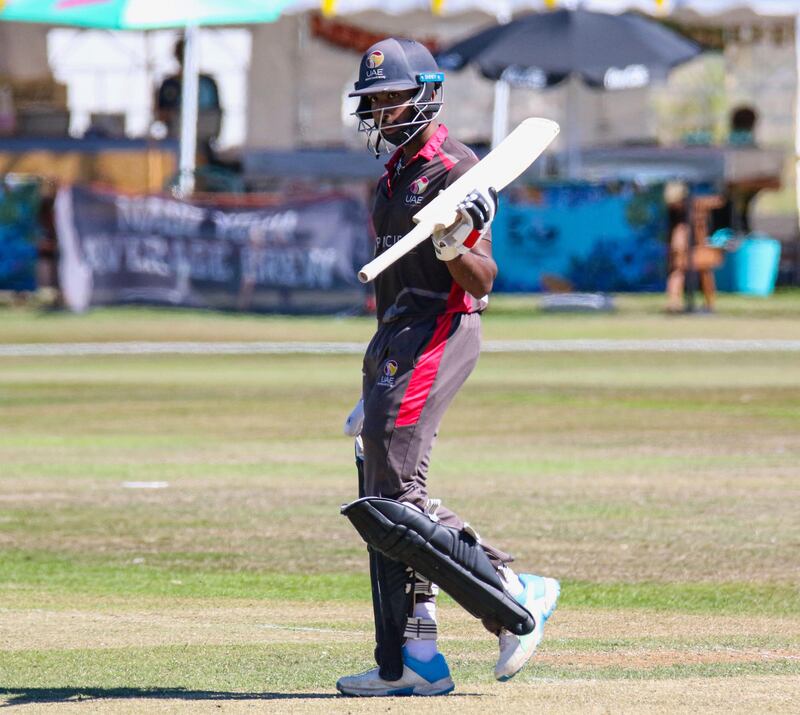 UAE batter Vriitya Aravind raises his bat after reaching a half-century. 