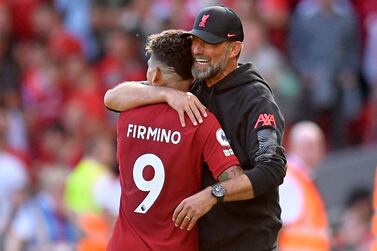 Liverpool's German manager Jurgen Klopp (R) embraces Liverpool's Brazilian striker Roberto Firmino (L) as he is substituted during the English Premier League football match between Liverpool and Bournemouth at Anfield in Liverpool, north west England on August 27, 2022.  (Photo by Oli SCARFF / AFP) / RESTRICTED TO EDITORIAL USE.  No use with unauthorized audio, video, data, fixture lists, club/league logos or 'live' services.  Online in-match use limited to 120 images.  An additional 40 images may be used in extra time.  No video emulation.  Social media in-match use limited to 120 images.  An additional 40 images may be used in extra time.  No use in betting publications, games or single club/league/player publications.   /  