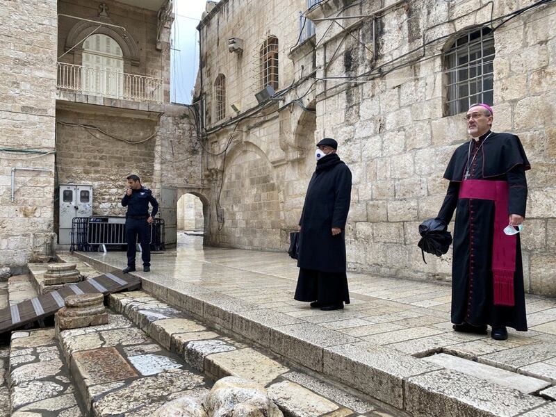 Archbishop Pierbattista Pizzaballa, apostolic administrator of the Latin Patriarchate of Jerusalem stands at the entrance to the Church of the Holy Sepulchre for the Good Friday service. Reuters