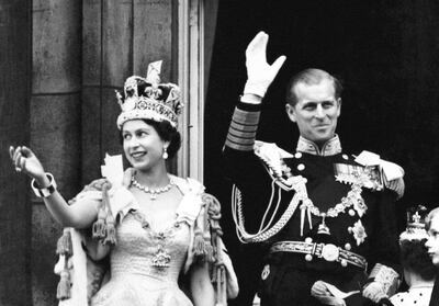 Queen Elizabeth II and Prince Philip wave to crowds from Buckingham Palace balcony on the day of her coronation. PA

