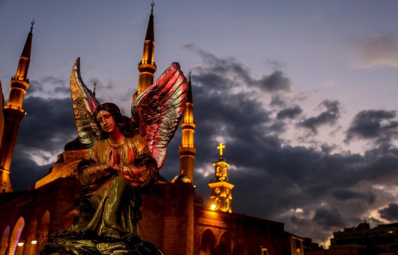 A statue of an angel in front of the Al Ameen mosque is lit up against the sunset in central Beirut.  EPA