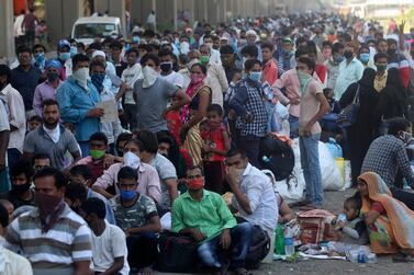 Migrant workers queue in Dharavi, a slum in Mumbai, for buses to take them back to their home states on May 22 - two months after lockdown measures were introduced that stopped many of them from working.  AP Photo