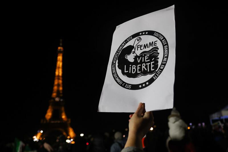 A woman holds a sign reading 'Woman, Life, Freedom' prior to a display of the words 'Woman, Life, Freedom' on the Eiffel Tower in Paris, France, 16 January 2023. EPA