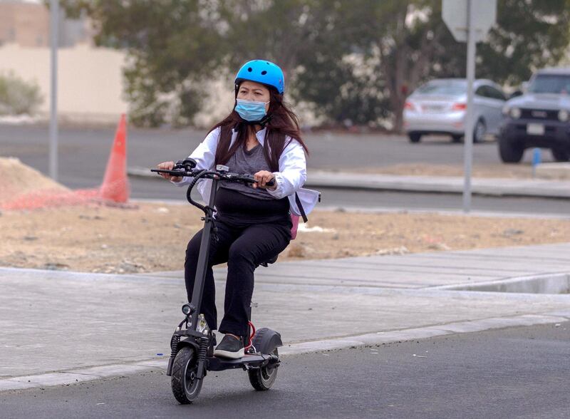 Abu Dhabi, United Arab Emirates, January 3, 2021.  A Khalifa City resident on her way to work on an e-scooter during hazy weather.
Victor Besa/The National
Section:  NA/Weather