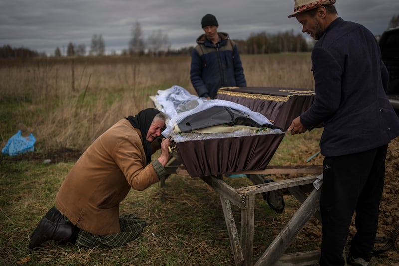 Nadiya Trubchaninova, 70, cries while holding the coffin of her son Vadym, 48, who was killed by Russian soldiers last March 30 in Bucha, during his funeral in the cemetery of Mykulychi, on the outskirts of Kyiv, Ukraine.  After nine days since the discovery of Vadym's corpse, finally Nadiya could have a proper funeral for him.  This is not where Nadiya Trubchaninova thought she would find herself at 70 years of age, hitchhiking daily from her village to the shattered town of Bucha trying to bring her son's body home for burial. AP