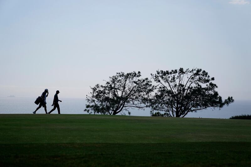 Justin Rose, of England, right, and his caddy walk up the fourth fairway during the first round of the US Open, at Torrey Pines in San Diego. AP Photo